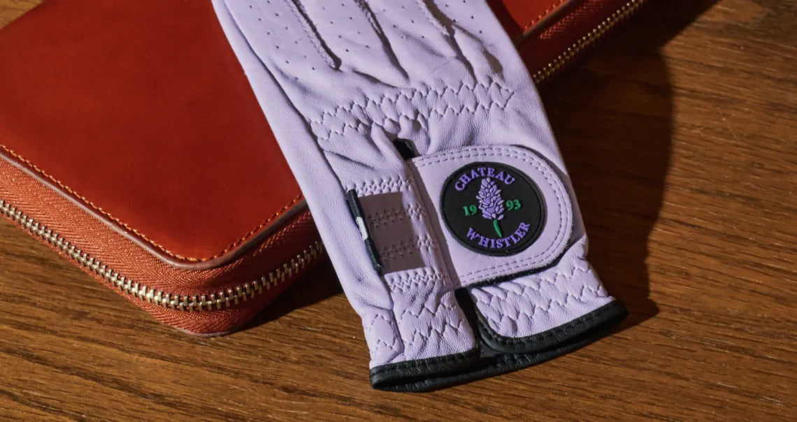 White golf glove with a brand logo on a wooden surface